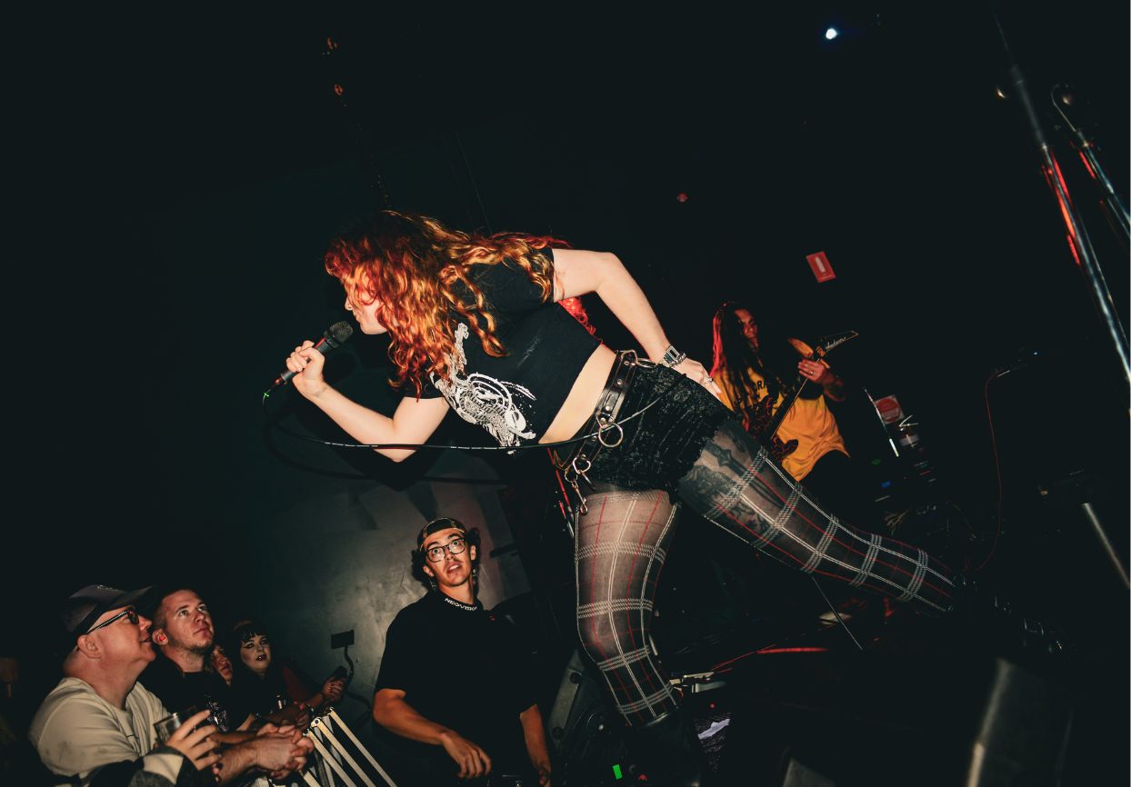 Boudicca performing on stage at a live punk show
